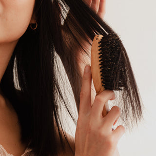 Why should you use a boar bristle brush instead of a plastic hairbrush?