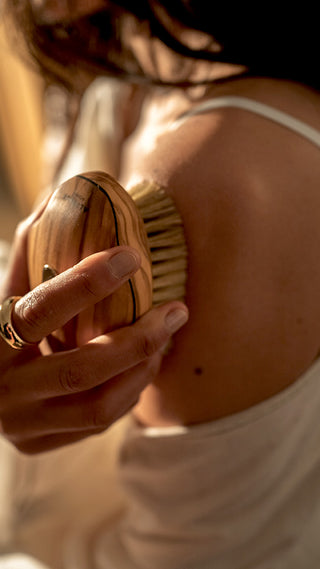 Dry arm brushing with Vitalis Altesse Studio body brush in olive wood and natural fibers